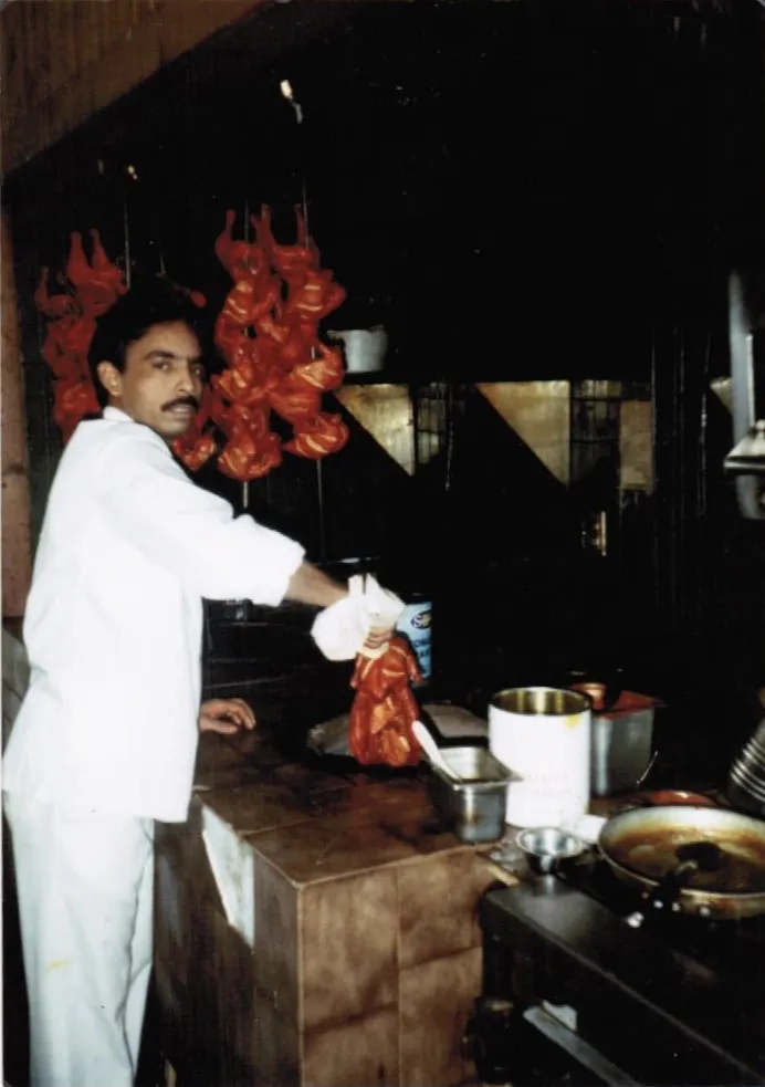 Archive photo of a chef at the tandoor with skewered chicken